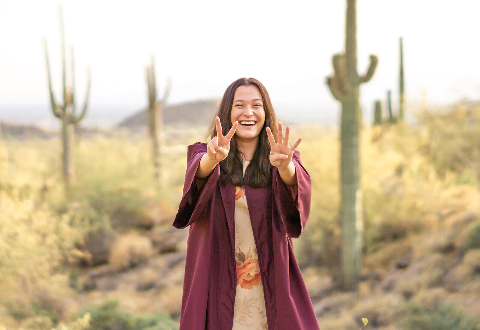 ASU graduate desert photo with fingers doing forks up