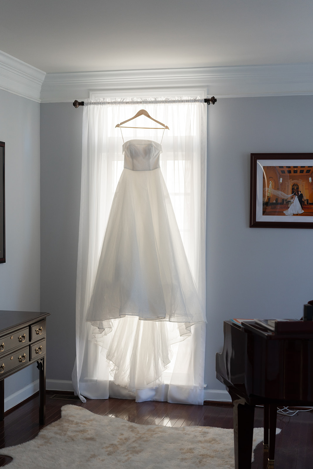 strapless white wedding dress hanging from a window