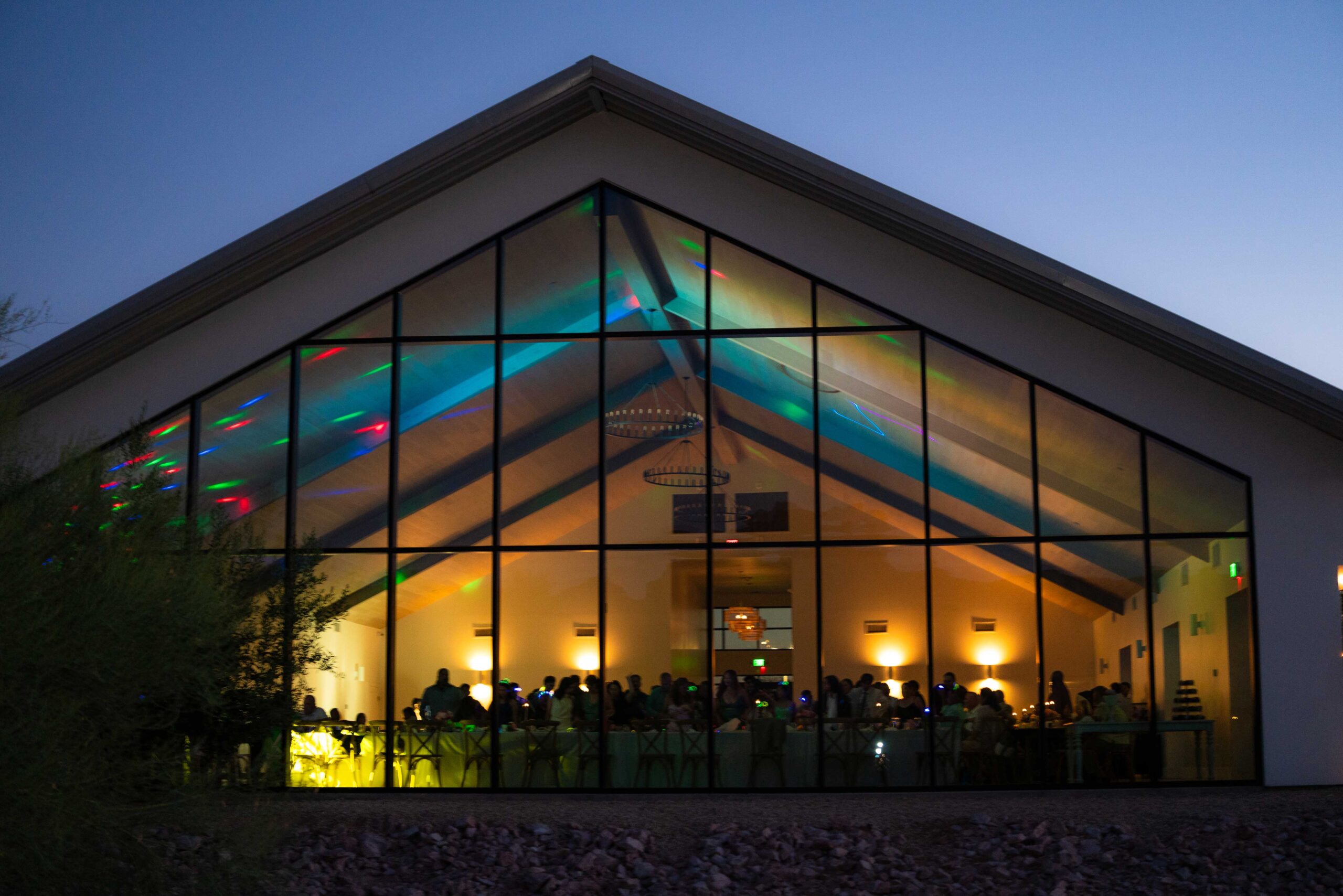 outside of desert views wedding venue at night with blue lights inside