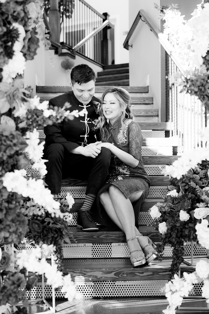 black and white photo of couple sitting on stairs during portraits after their tea ceremony