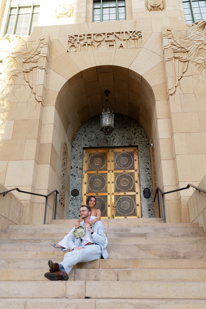 bride and groom after eloping in phoenix courthouse, sitting on phoenix city hall steps.jpg