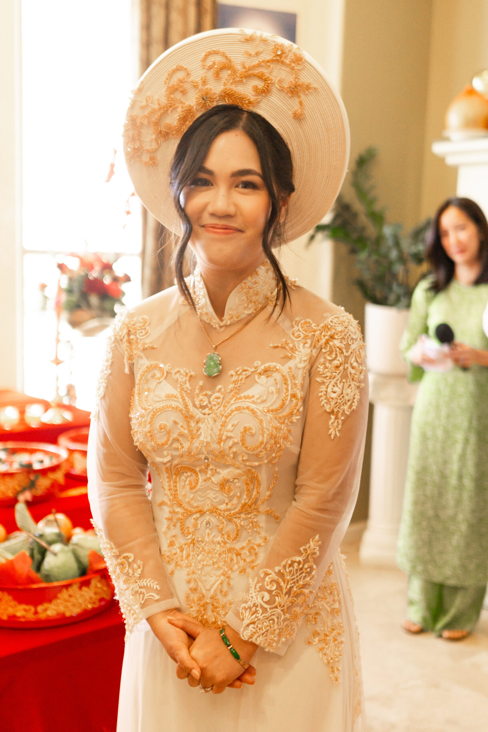 bride wearing gold ao dai during tea ceremony