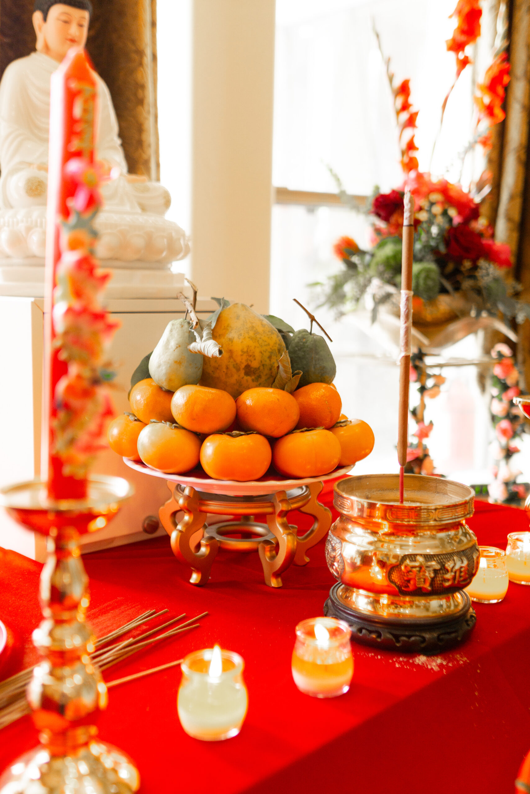 persimmons and other fruit on a gift tray, on a red altar table for a tea ceremony