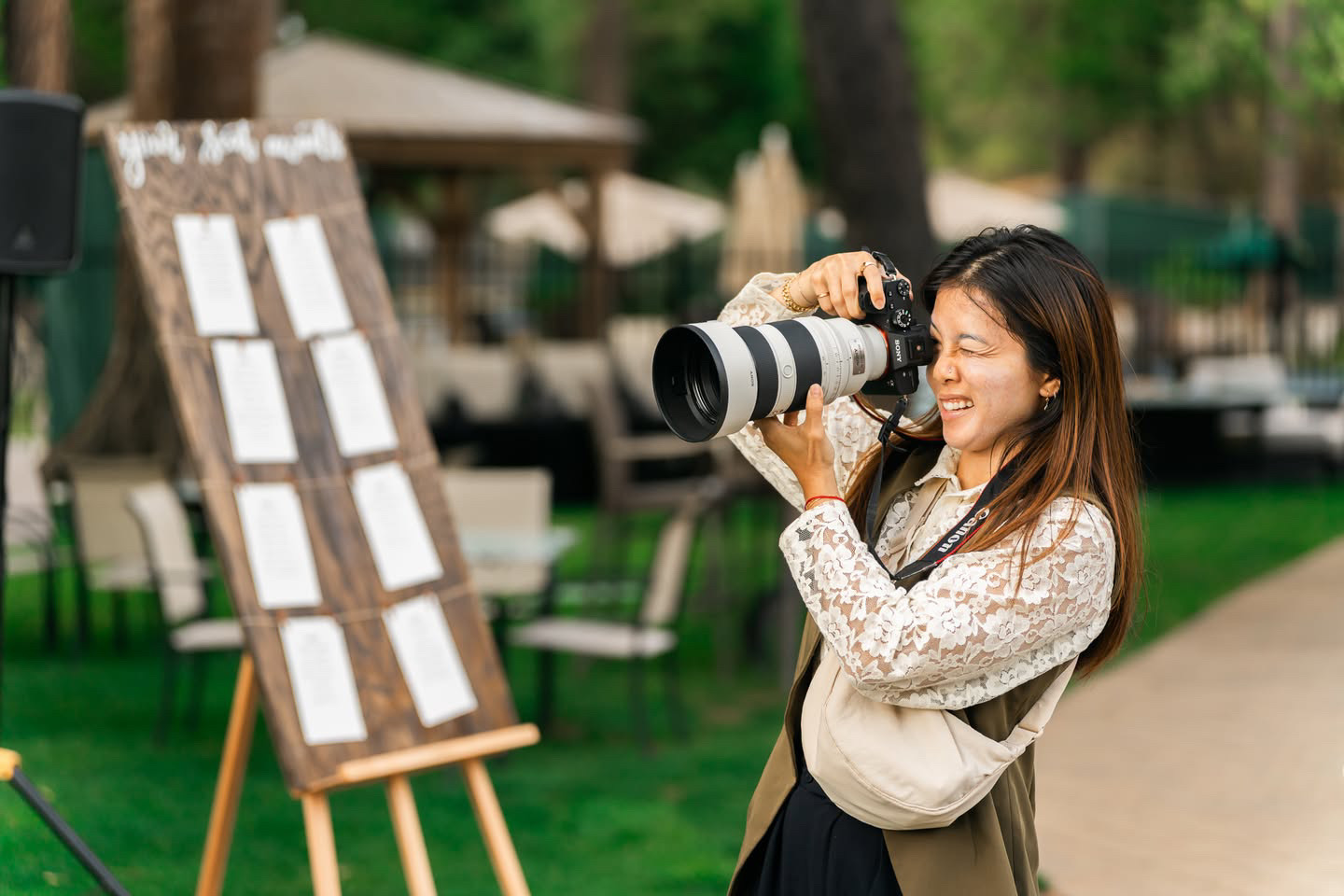 woman using a sony 50-150mm f2 to shoot at a wedding