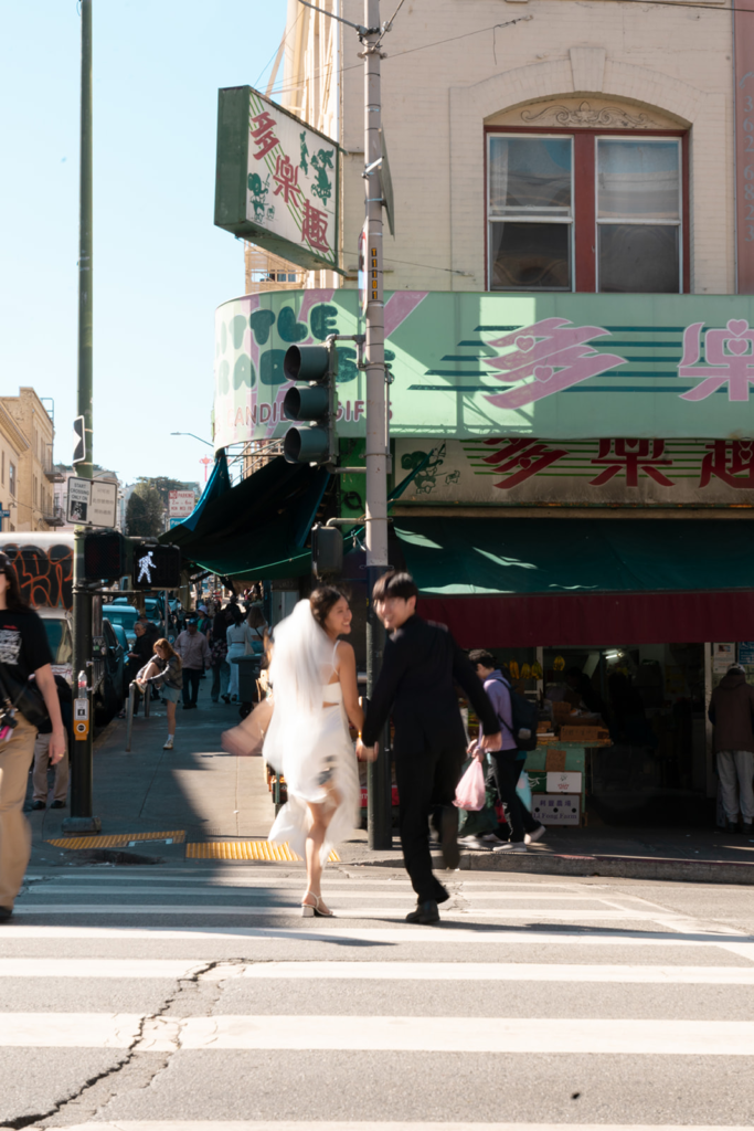 running through san francisco chinatown during an engagement photoshoot
