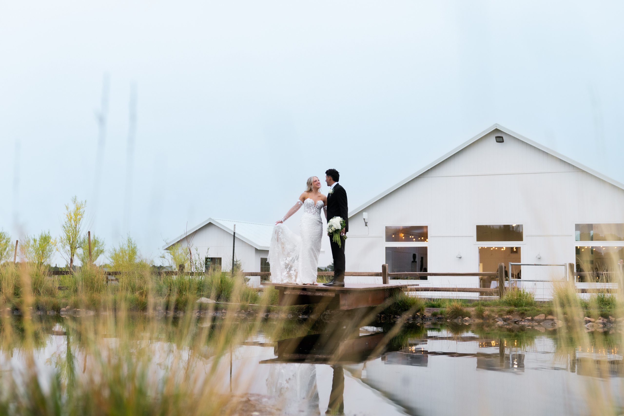 Bride and groom standing on the dock at the Sycamore wedding venue in flagstaff