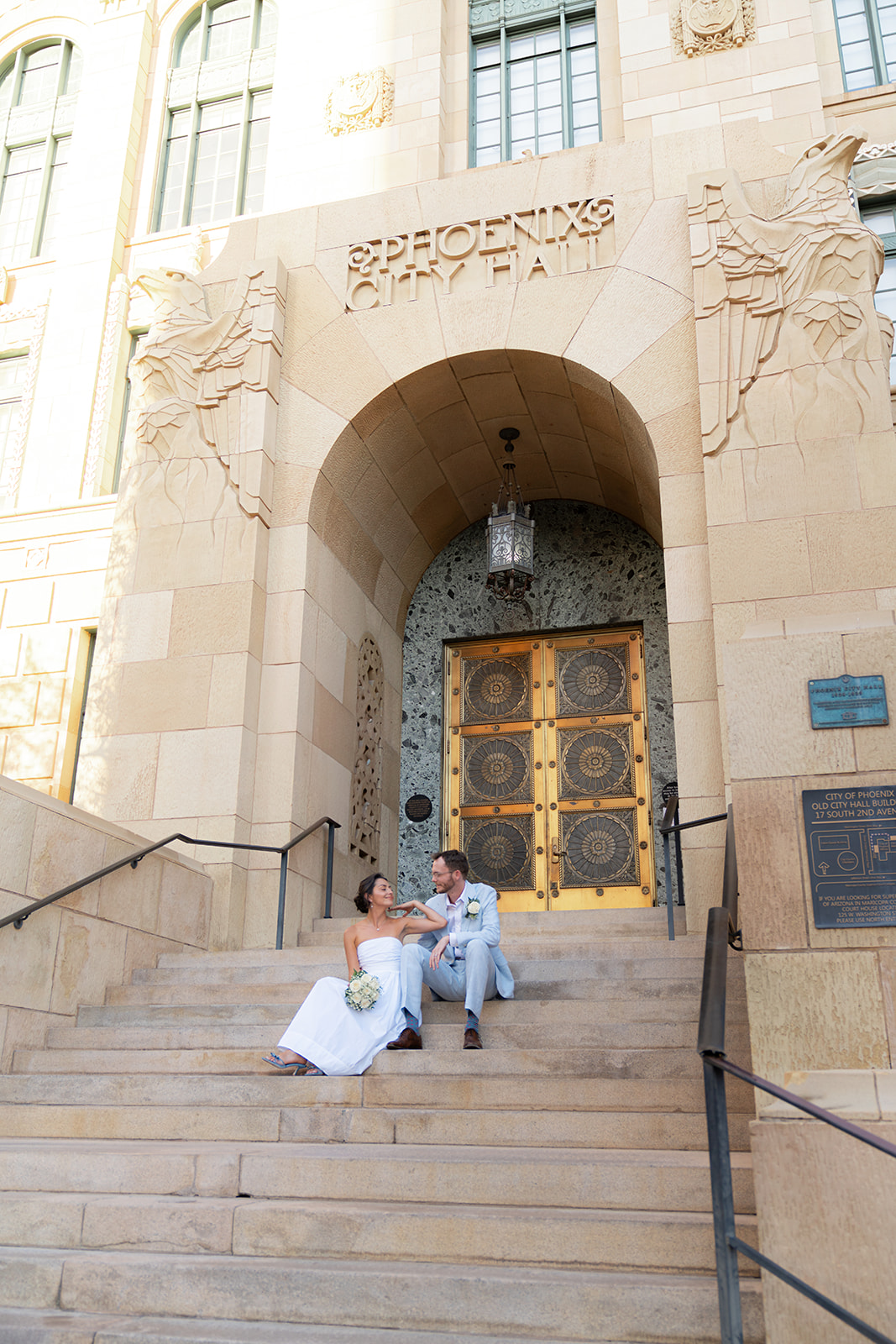 couple sitting on the steps of phoenix city hall courthouse