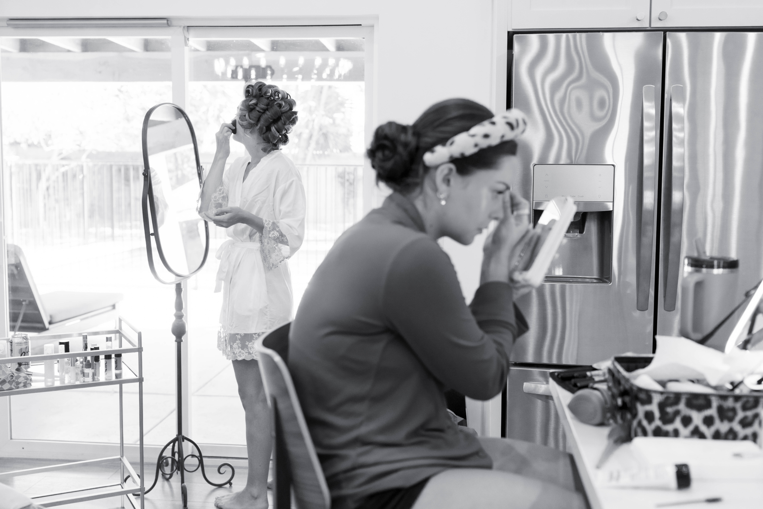 black and white photo of two girls getting ready and putting makeup on