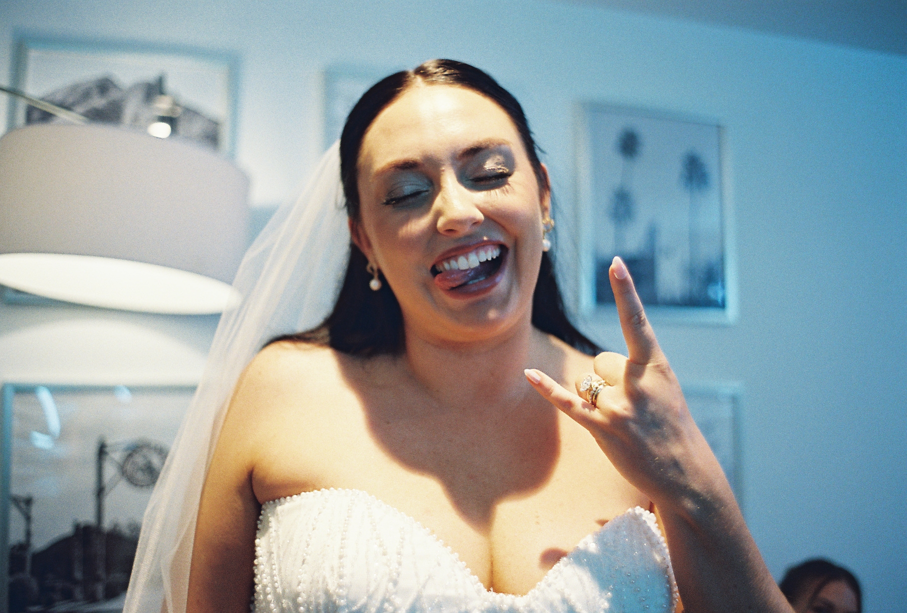Bride making silly face and doing rock on signal