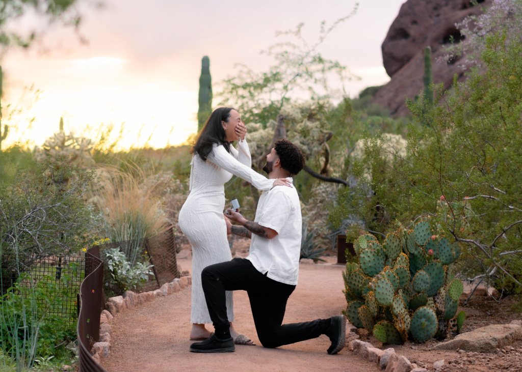 Man proposing to woman on one knee at desert botanical garden in phoenix, az