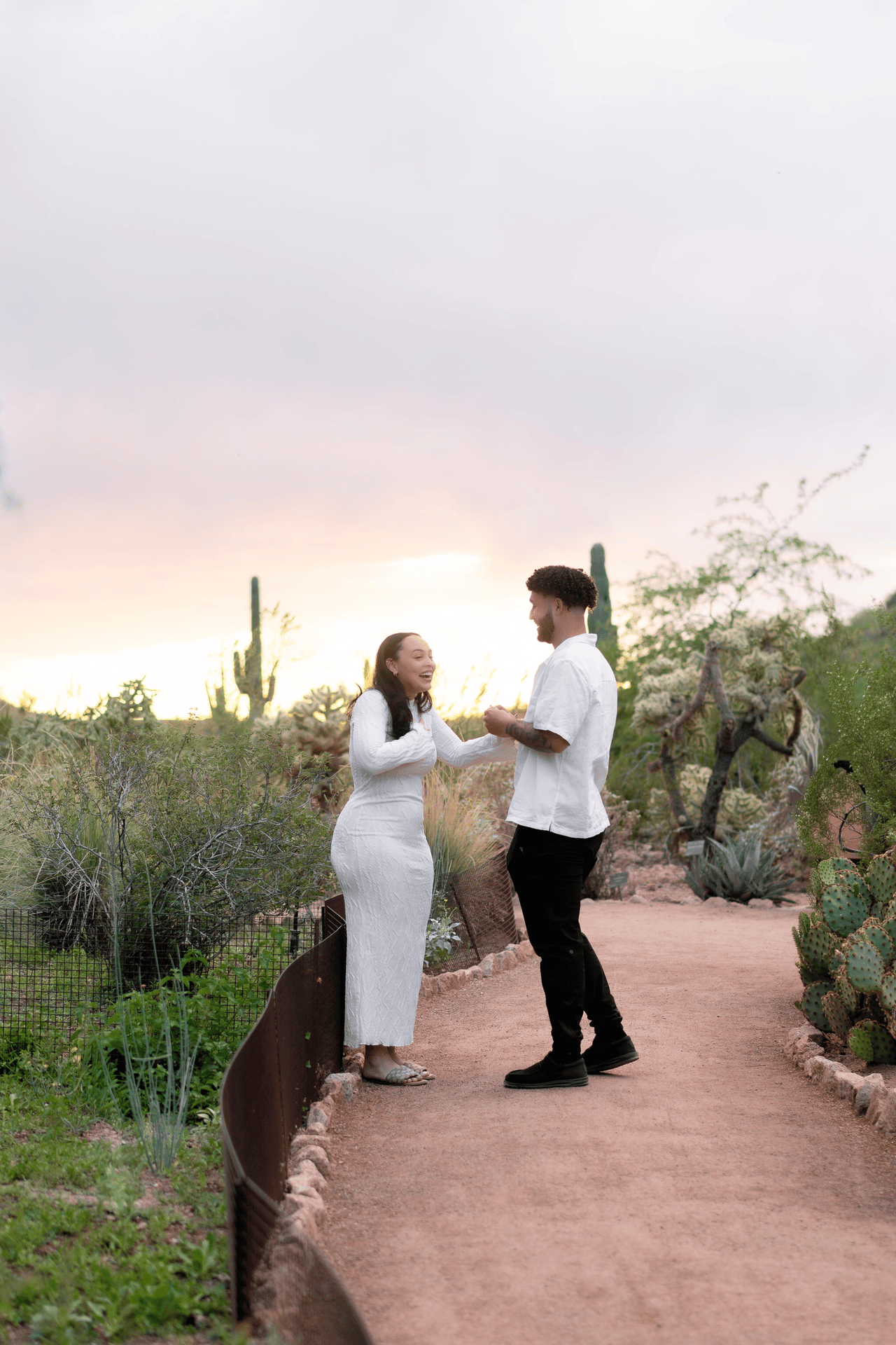 woman being surprised after being proposed to at the desert botanical garden in phoenix, arizona